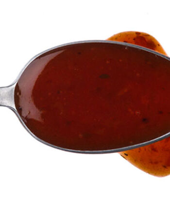 Asian tofu marinade on a spoon drizzled onto a white background.