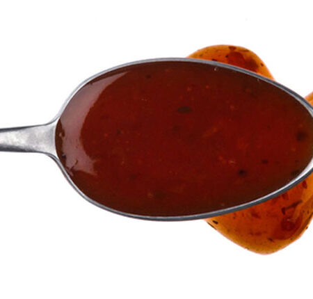 Asian tofu marinade on a spoon drizzled onto a white background.