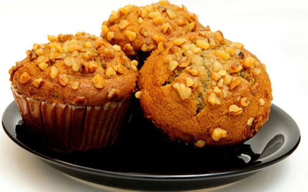 three banana nut muffins on a black plate