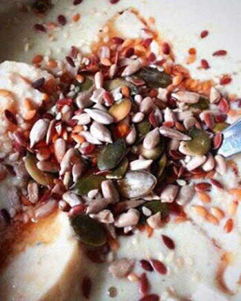 porridge with cut banana, nuts, and seeds