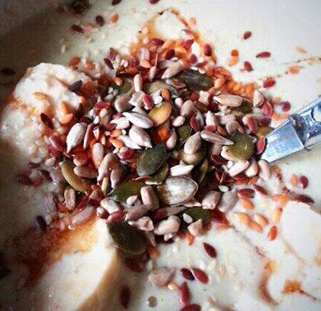 porridge with cut banana, nuts, and seeds