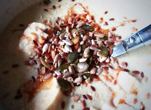 porridge with cut banana, nuts, and seeds