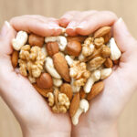 Woman's hands holding a variety of nuts.