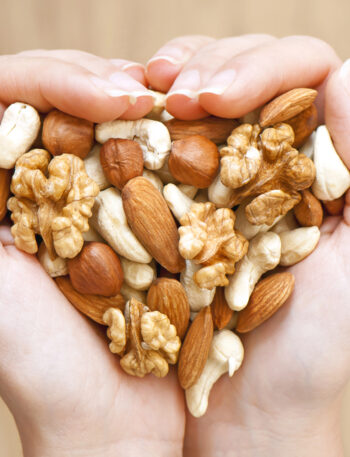 Woman's hands holding a variety of nuts.