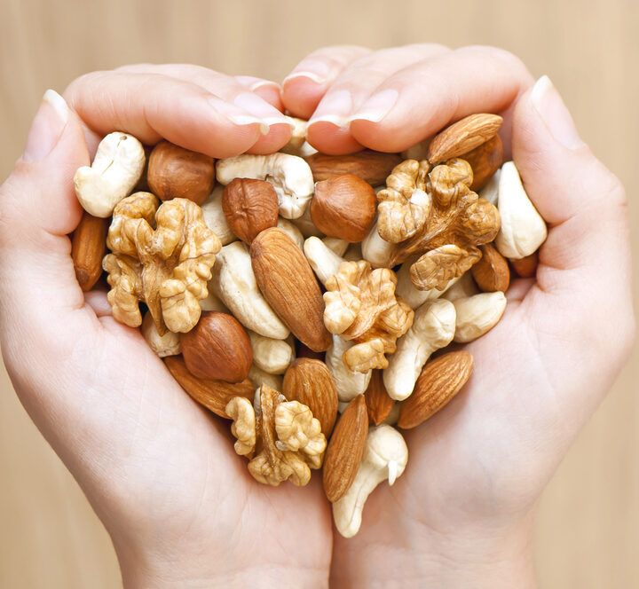 Woman's hands holding a variety of nuts.