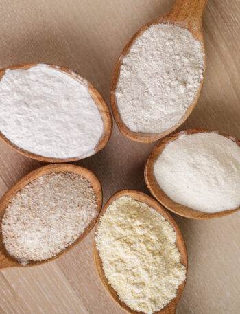 5 spoons holding different types of gluten-free flour.