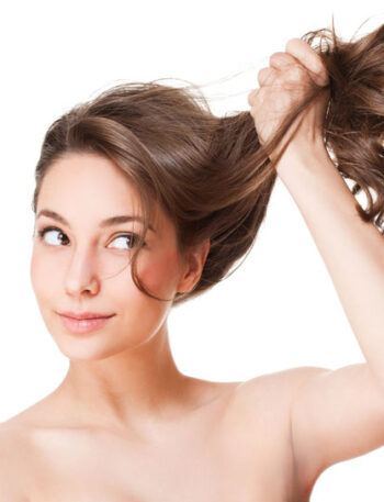 Young woman holding her long hair up and off to the side.
