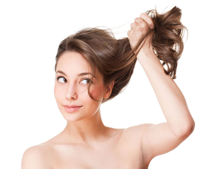 Young woman holding her long hair up and off to the side.