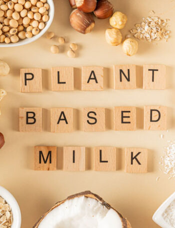 Nuts and grains used to make plant-based milk with the lettering "Plant Based Milk" arranged in the center.