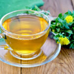 Cup of rhodiola tea next to a rhodiola plant/flower.