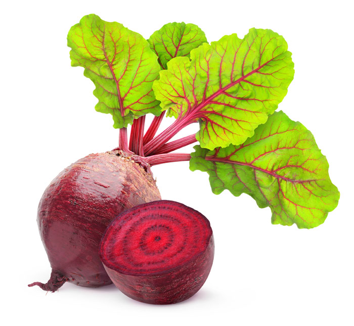 A whole beet with greens attached and a halved beet on a white background.