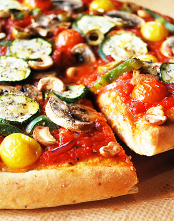 Veggie supreme pizza with a cut slice being pulled out.