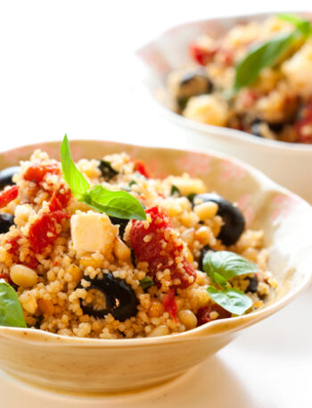 Two bowls of Mediterranean Couscous Salad on a white background.
