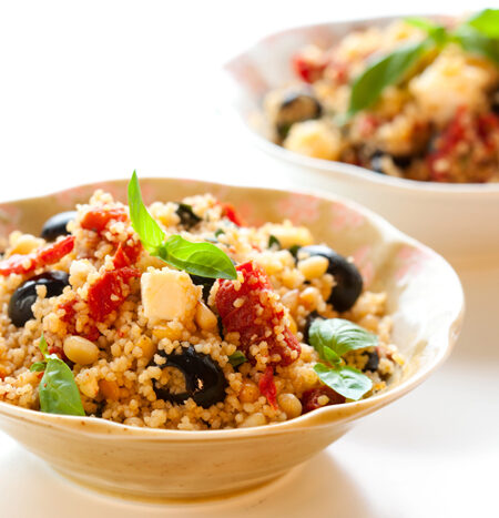 Two bowls of Mediterranean Couscous Salad on a white background.