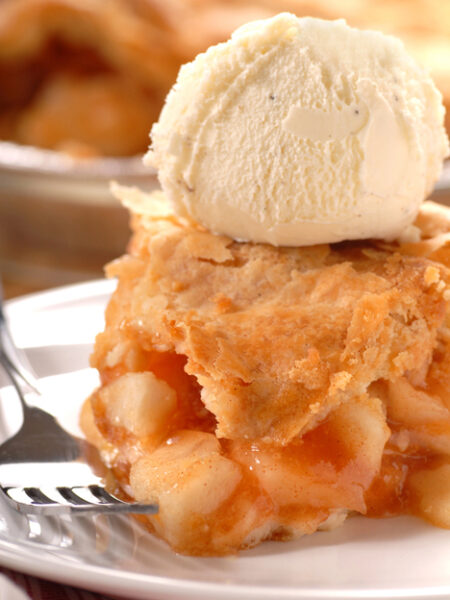 Deep Dish Apple Pear Pie on a plate with a scoop of vanilla ice cream on top.