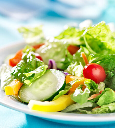 Classic Garden Salad on a white plate with a blue background.