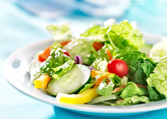 Classic Garden Salad on a white plate with a blue background.