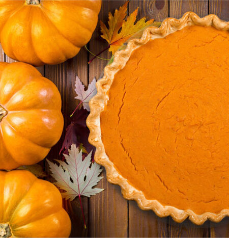 Creamy Vegan Pumpkin Pie next to 3 small pumpkins.